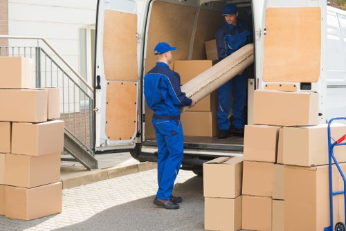 Removal team carefully loading household items in Brent