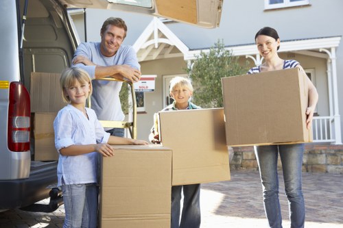 Trained removal staff wearing PPE while moving furniture safely