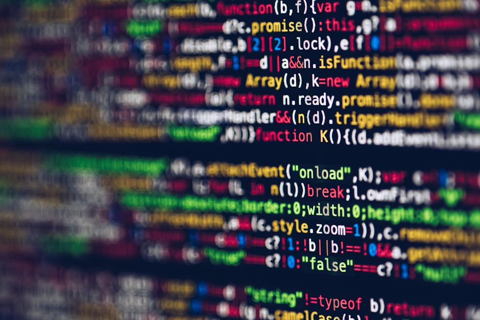 A close-up photograph of a computer screen displaying multicolored lines of code in various programming languages, with elements such as functions, variables, and syntax highlighted in red, green, blu